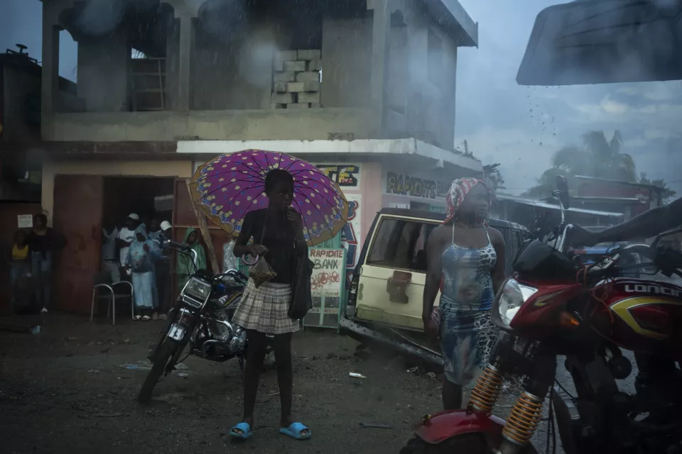 Person holding pink patterned umbrella standing on street