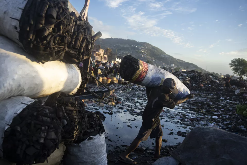 Person carrying large white sack on shoulder 