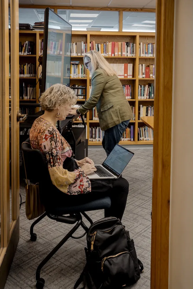 Volunteers from Holy Trinity Catholic Church prepare with Hakima for her remote court hearing