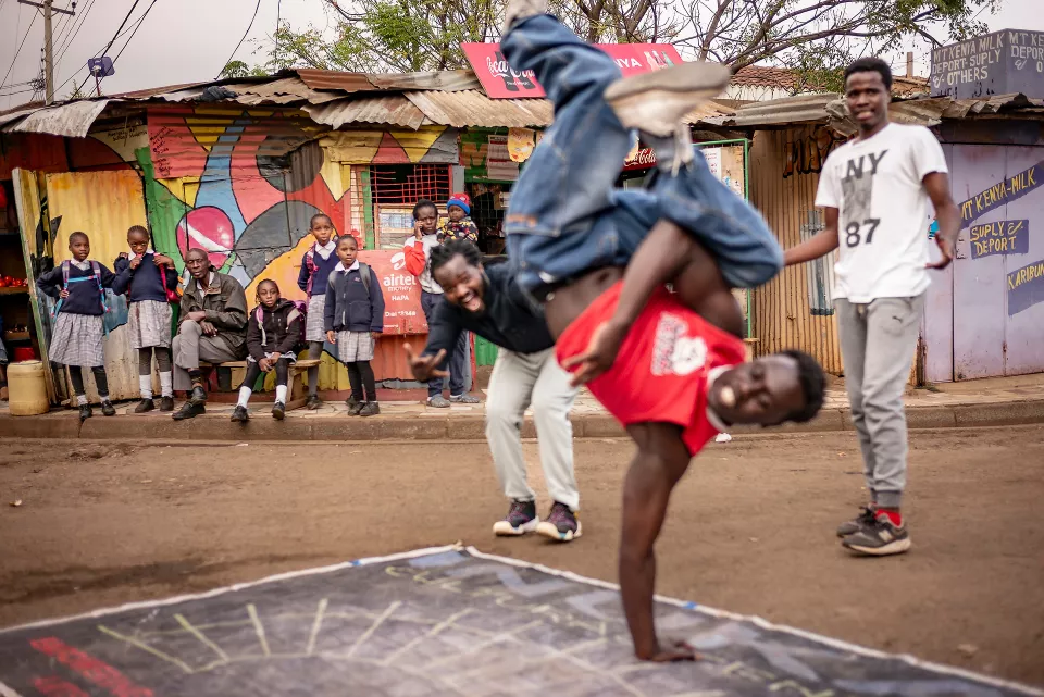 Youth performing acrobatic handstands on a marked outdoor surface