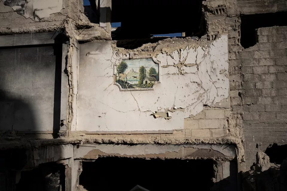 a green and mountainous landscape painted on the exposed wall of a destroyed building