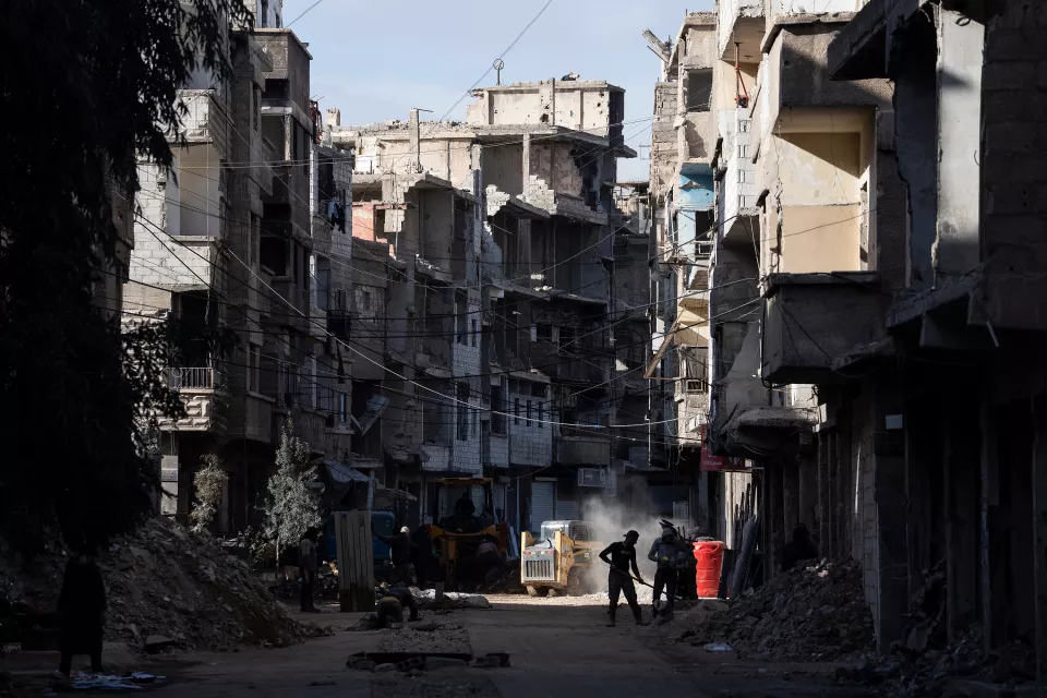 wide view of the city, shadows, and passersby in the sun