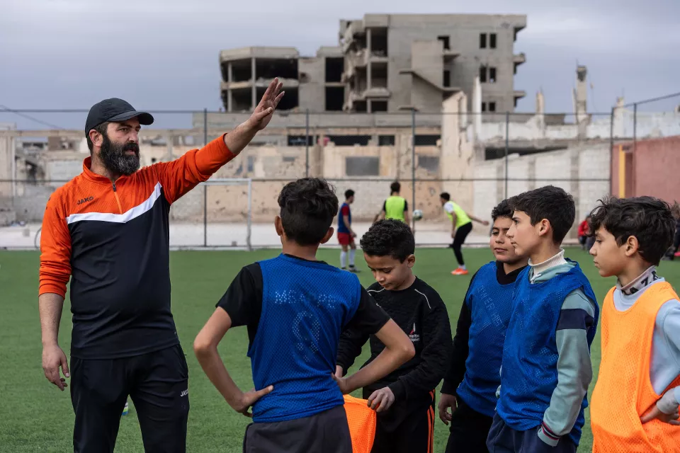 Yamin Hammeed, volunteer coaches young soccer player 