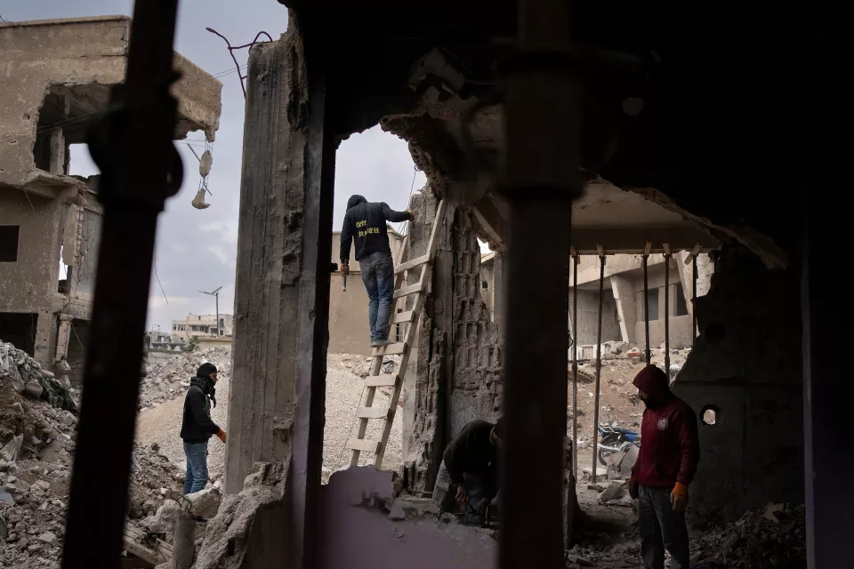 a worker on a ladder in the middle of ruins